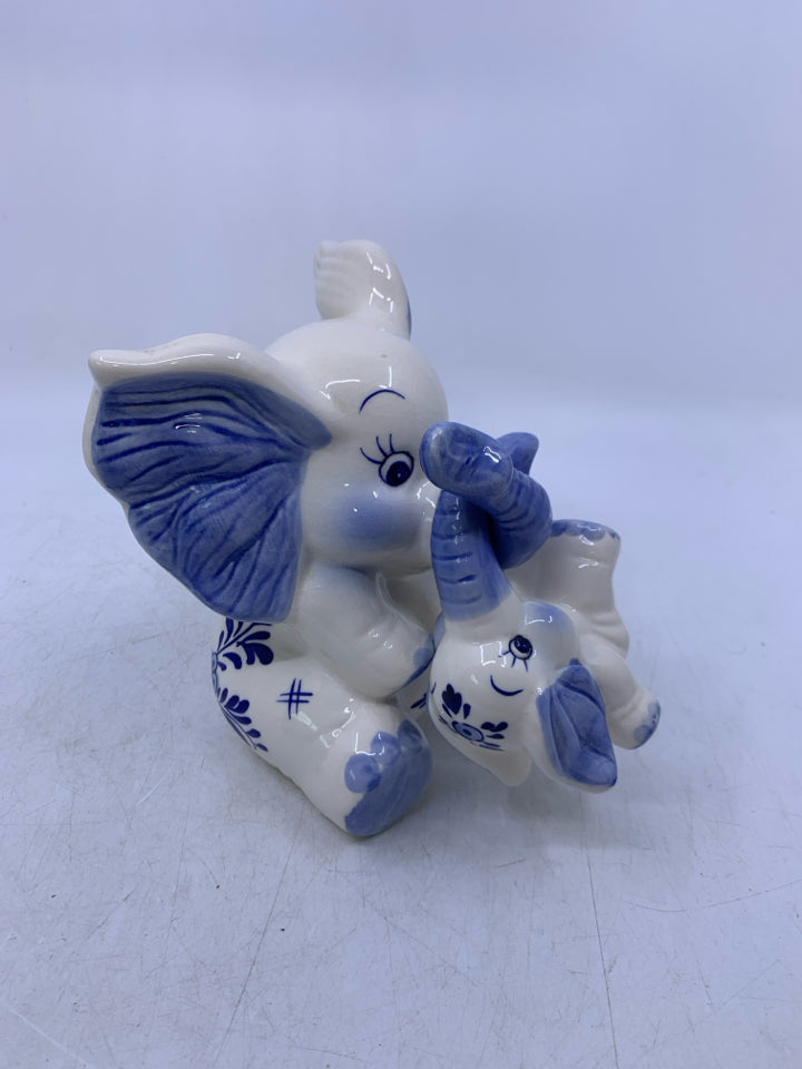 BLUE/WHITE SITTING ELEPHANT W/ BABY HANGING FROM TRUNK COIN BANK.