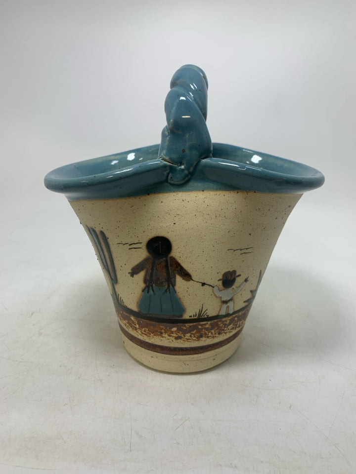 BASKET VASE W/ MOTHER/SON HOLDING HANDS LOOKING OUT LIGHT BLUE EDGES.