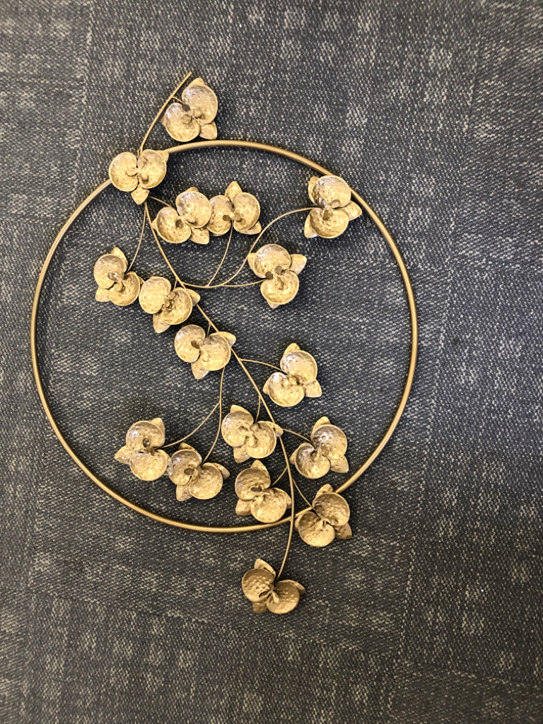 GOLD CIRCLE WITH FLORAL WALL HANGING.