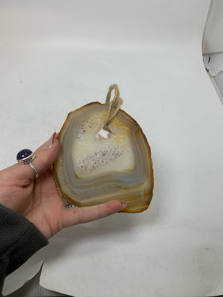 CRYSTAL ROCK SLICE W/ HOLE IN CENTER WALL HANGING.
