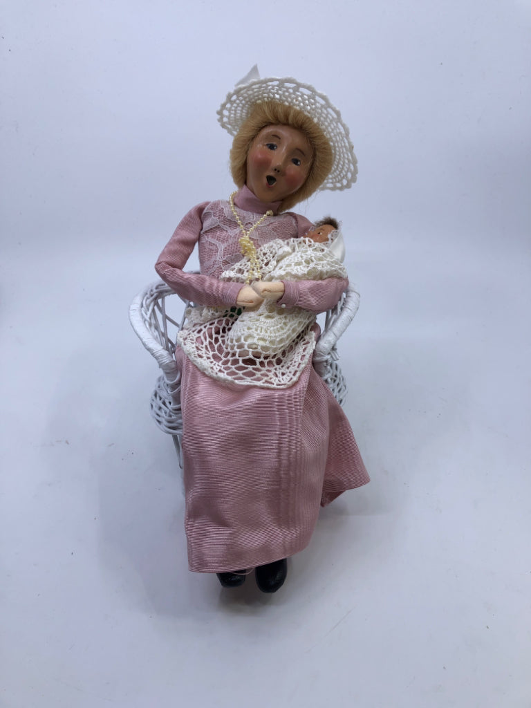 BYERS' CHOICE WOMAN HOLDING BABY SITTING IN CHAIR.
