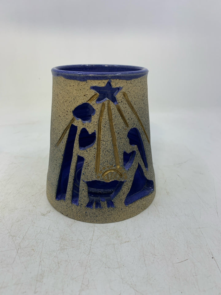 TEXTURED TAN POTTERY TEA LIGHT W/ MOTHER MARY/JOSEPH CUT OUT BLUE INSIDE.