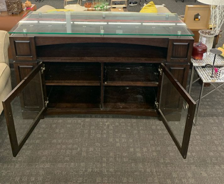 HEAVY DARK WOOD AND GLASS ENTERTAINMENT CENTER WITH SHELF AND CABINET STORAGE.