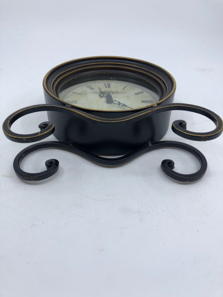METAL BLACK SCROLL FOOTED CLOCK W/ GOLD DETAILS.