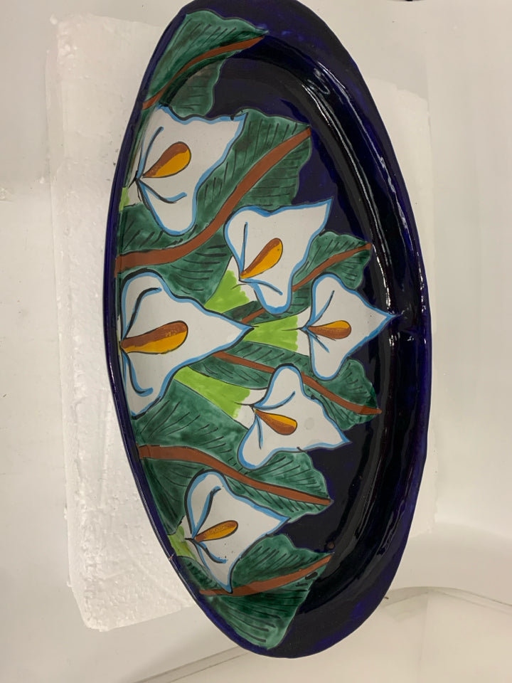 LARGE OVAL TERRA COTTA PLATTER W/ WHITE FLOWERS DARL BLUE BACKGROUND.