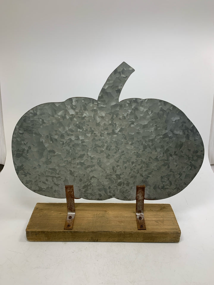 LARGE GALVANIZED PUMPKIN ON WOOD BOARD.