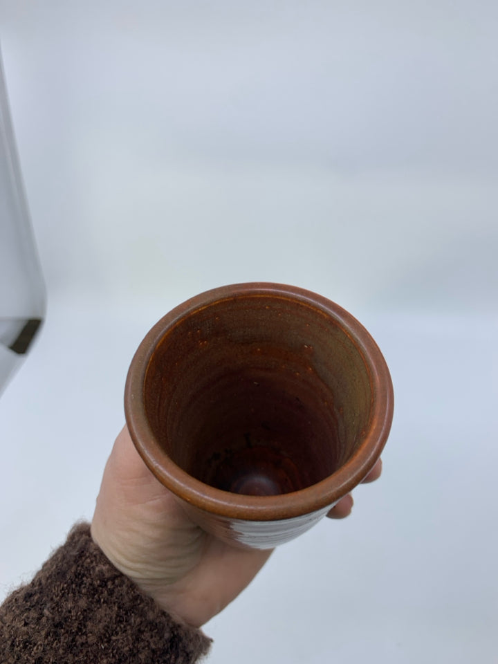 FOOTED RUST COLORED POTTERY VASE.