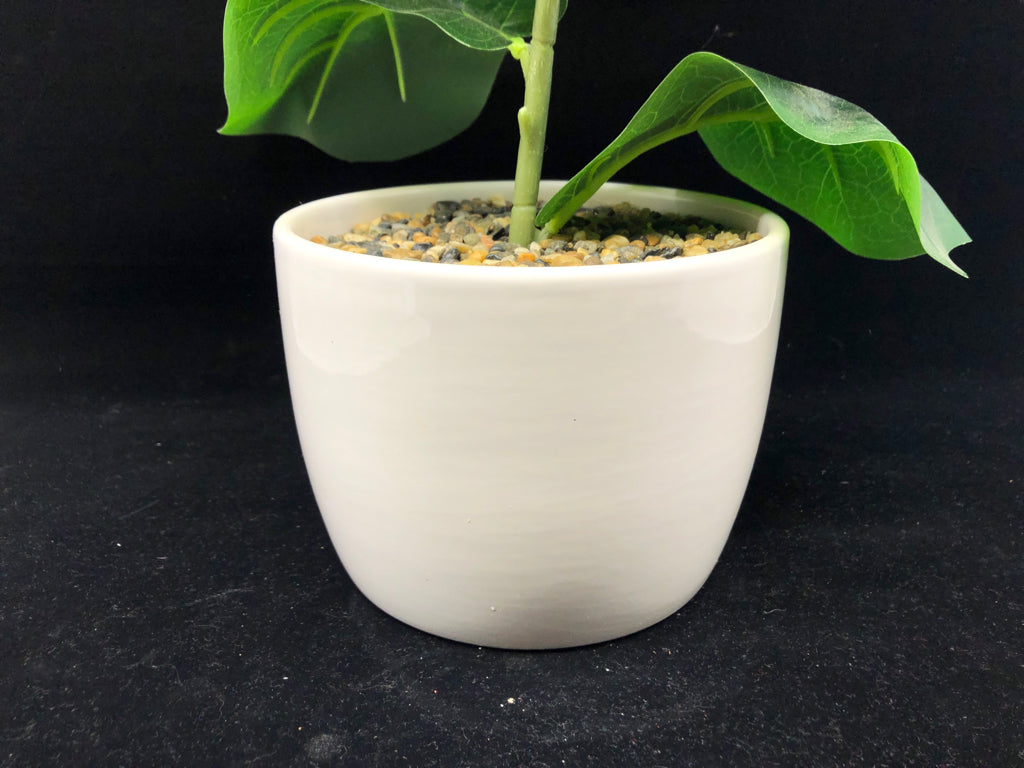 FAUX GREEN LEAVES IN WHITE PLANTER.