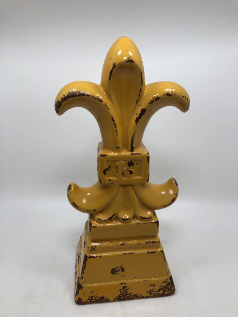 YELLOW FLEUR-DE-LIS FIGURINE.