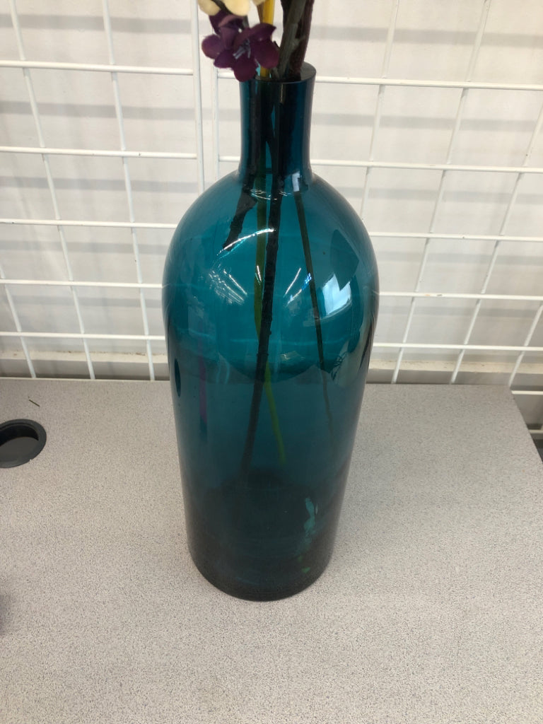 PURPLE FLORALS IN BLUE GLASS VASE.