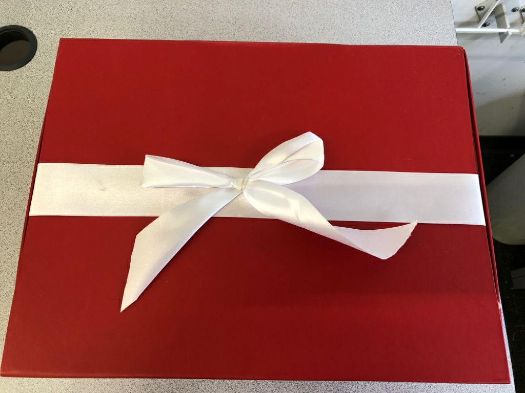 NIB RED BLANKET, IN GIFT BOX WITH WHITE RIBBON.