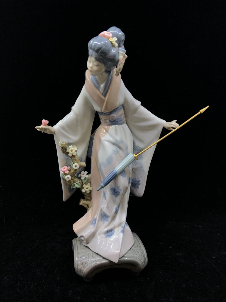 LLADRO WOMAN HOLDING UMBRELLA BENDING OVER.