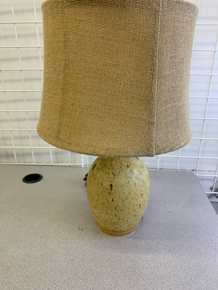 TAN POTTERY SPECKLED BASE LAMP W/ BURLAP SHADE.