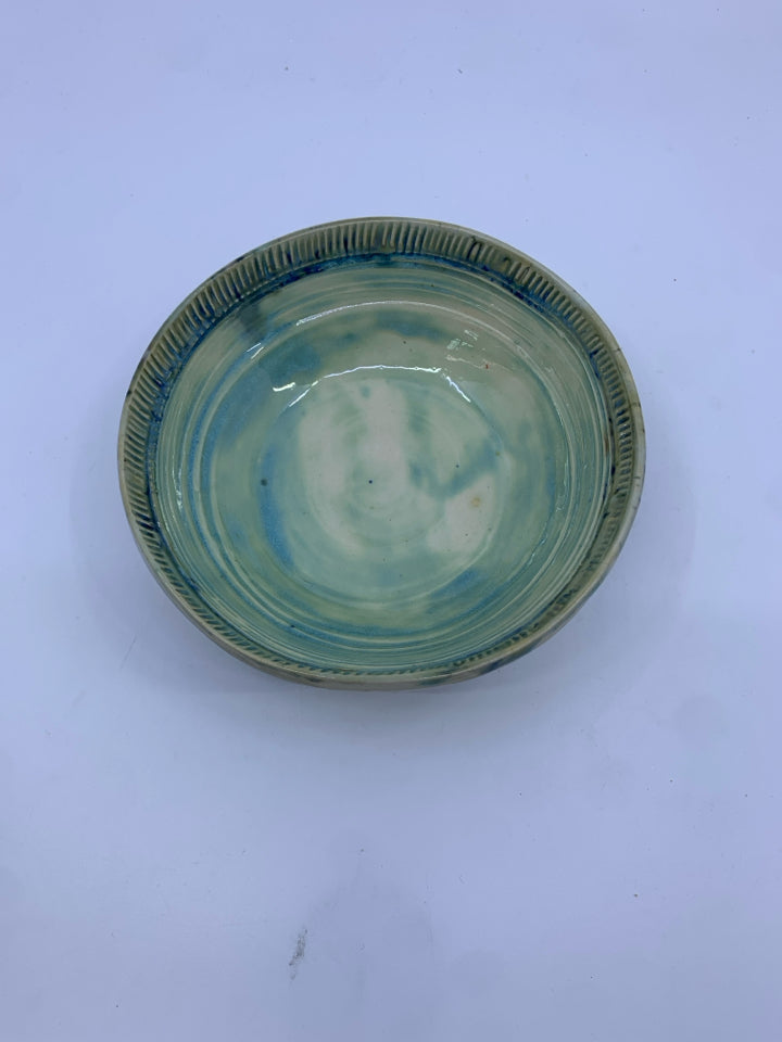 LIGHT GREEN POTTERY BOWL W/ SOME BLUE LINED EDGE.