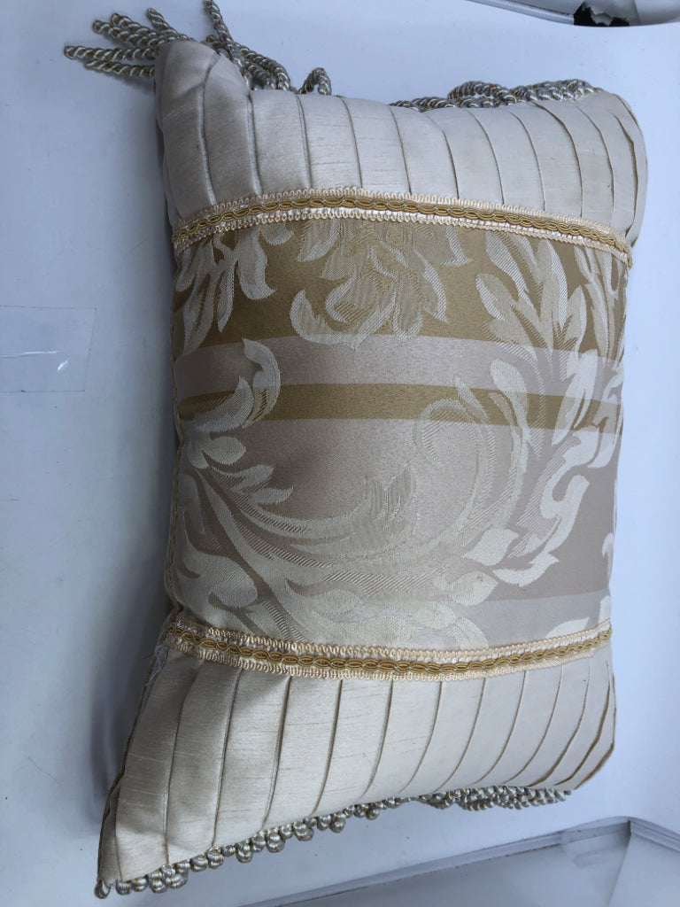 CREAM RECTANGLE AND GOLD PILLOW WITH TASSELS.