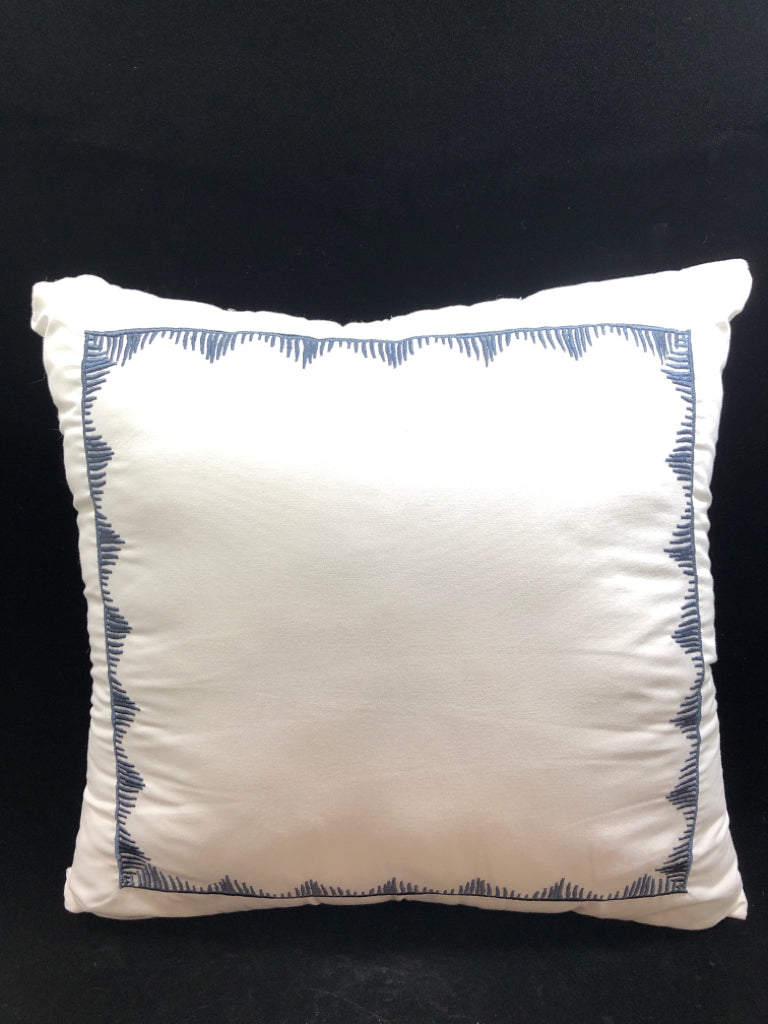 WHITE THROW PILLOW W/GEOMETRIC BLUE PATTERN.