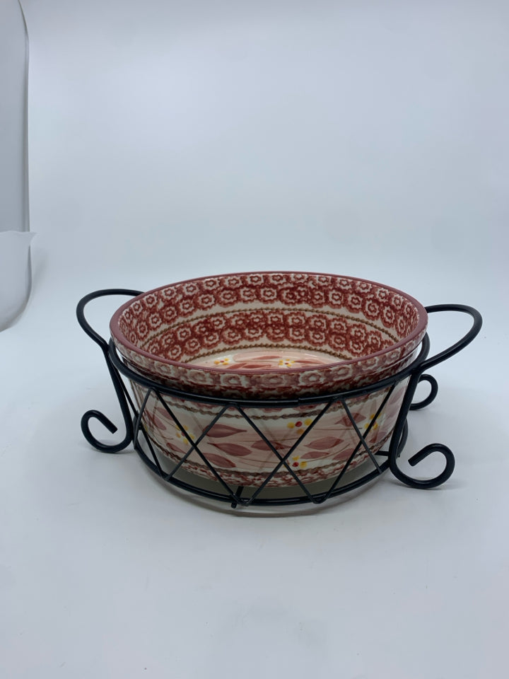 ROUND CASSEROLE DISH IN BLACK METAL STAND.