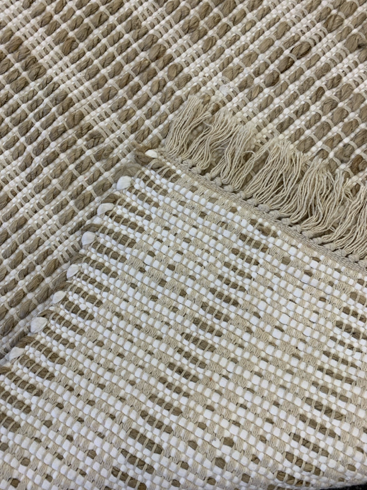 BROWN AND WHITE TASSEL AREA RUG.