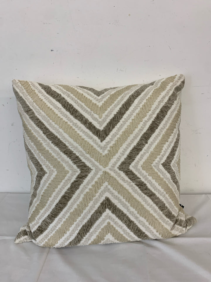 CREAM PILLOW W TAN AND BROWN CHEVRON PATTERN.