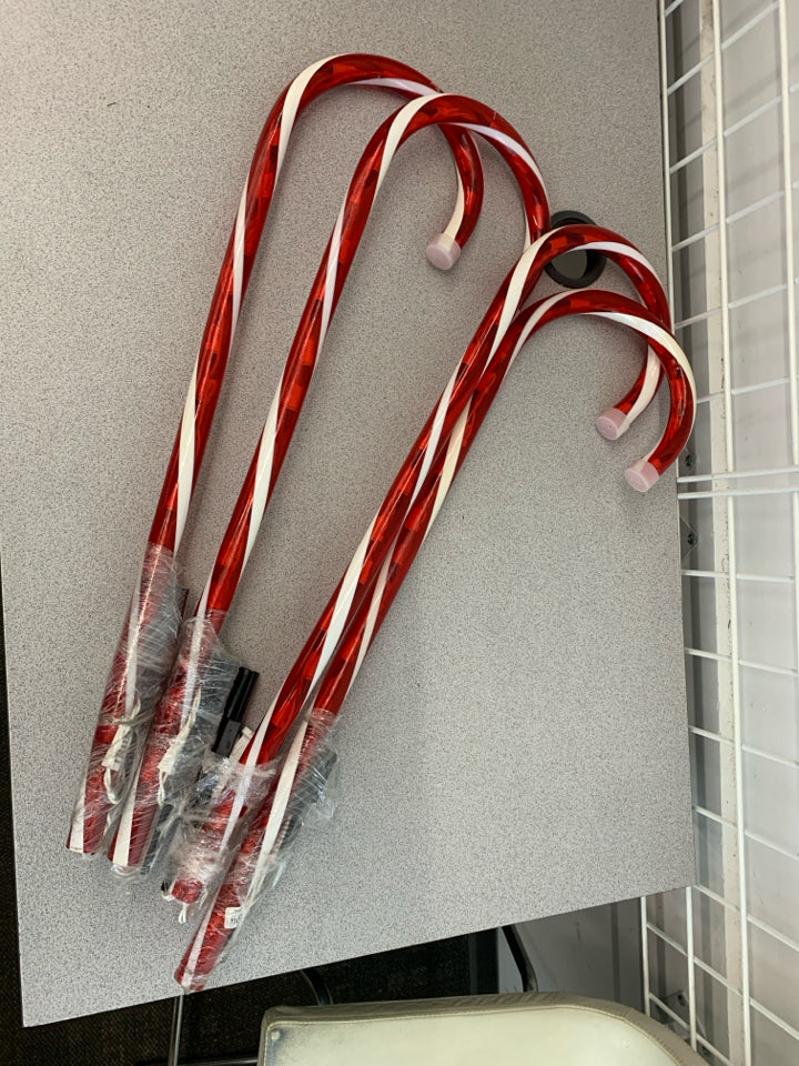 4 LIGHT UP CANDY CANES FOR YARD.