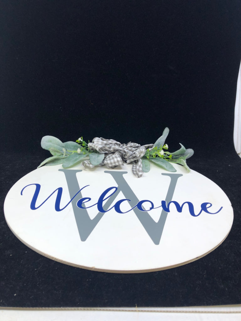 WHITE W GREENS ROUND WELCOME SIGN.