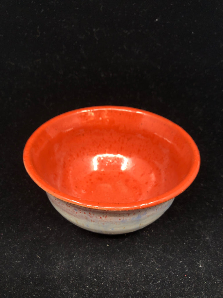 ORANGE POTTERY BOWL W LIGHT OUTSIDE.