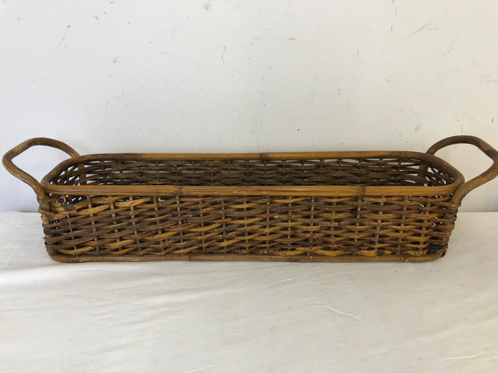 LONG WOVEN WICKER BASKET W/ DOUBLE HANDLES.