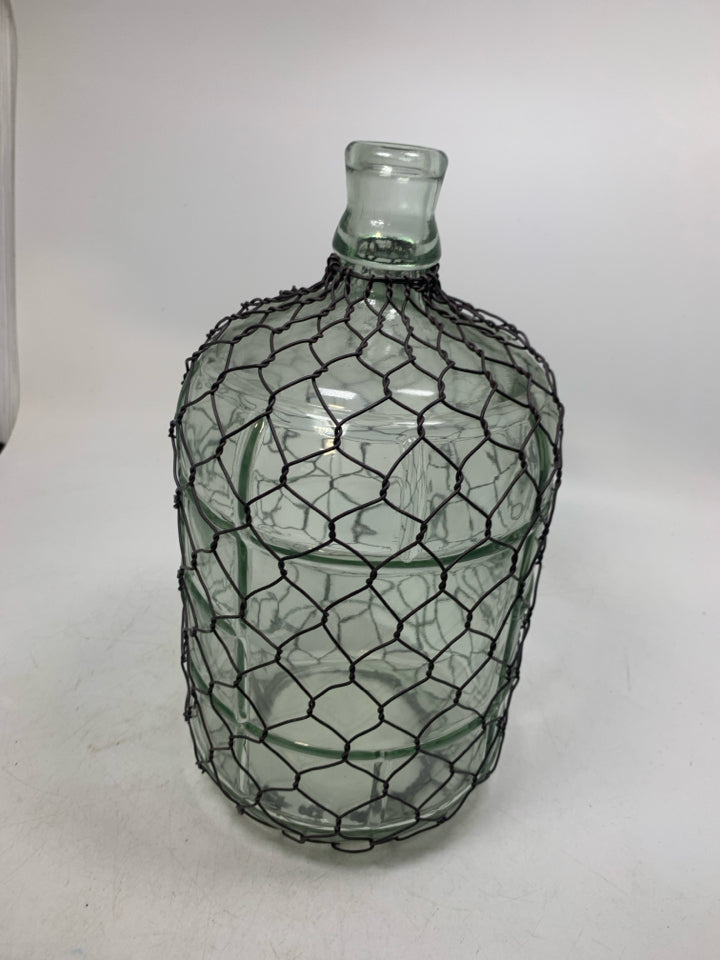 GLASS JUG W/ CHICKEN WIRE COVERING.