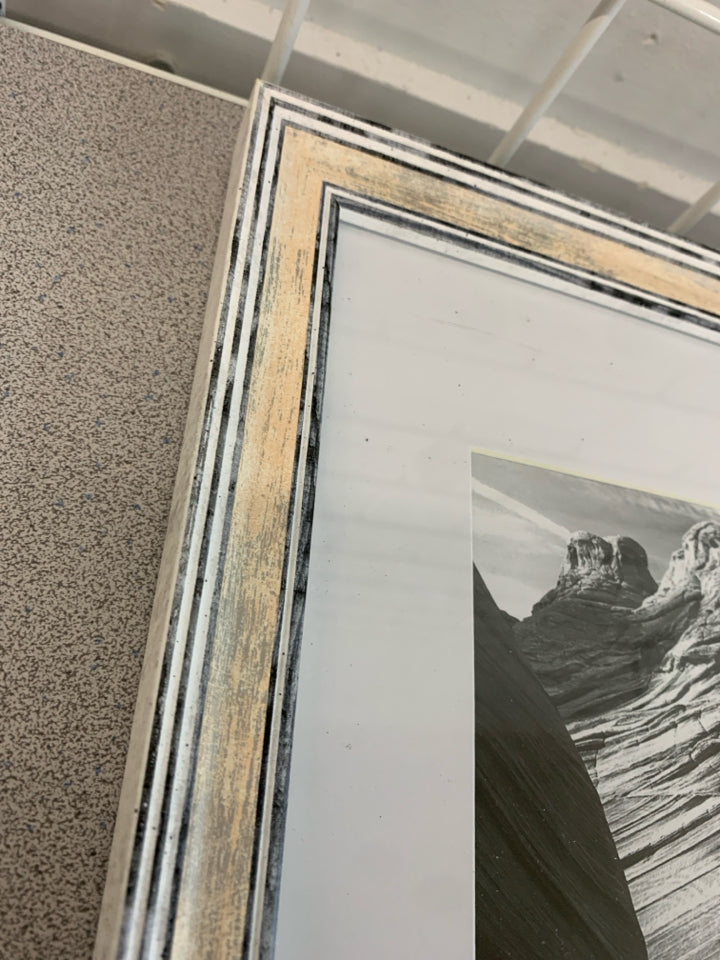 ROCK FORMATION BLACK/WHITE IN WHITE WASHED FRAME.