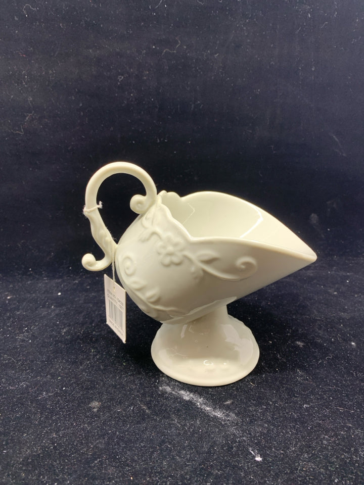 CREAM FOOTED FLORAL SCROLL EMBOSSED TILTED GRAVY BOAT.