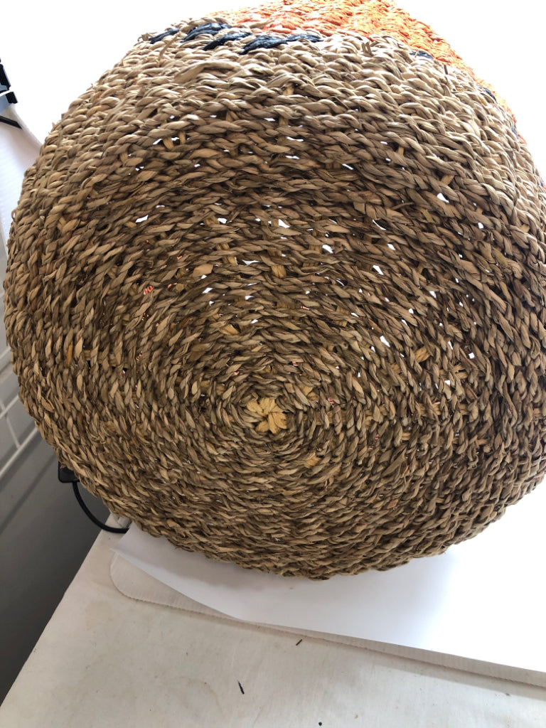 ORANGE AND TAN WICKER BASKET WITH BLUE ACCENTS.
