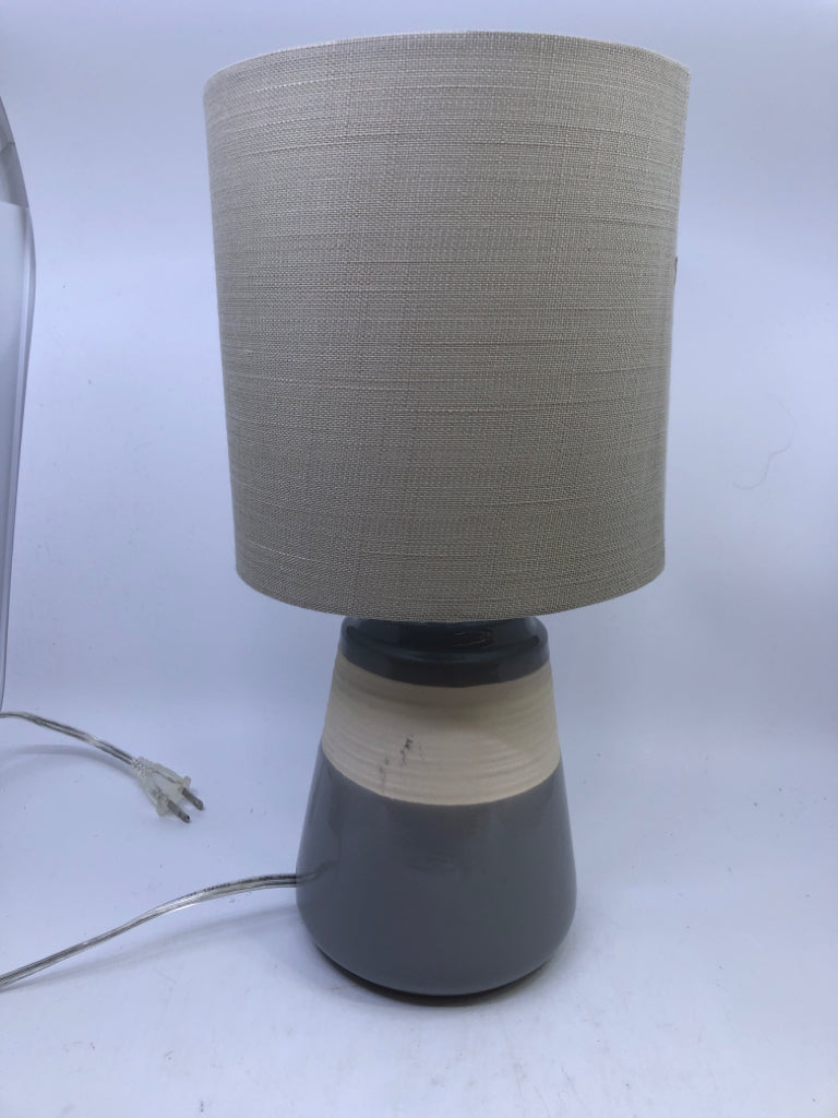 GREY/CREAM CERAMIC BASE LAMP W/TAN SHADE.