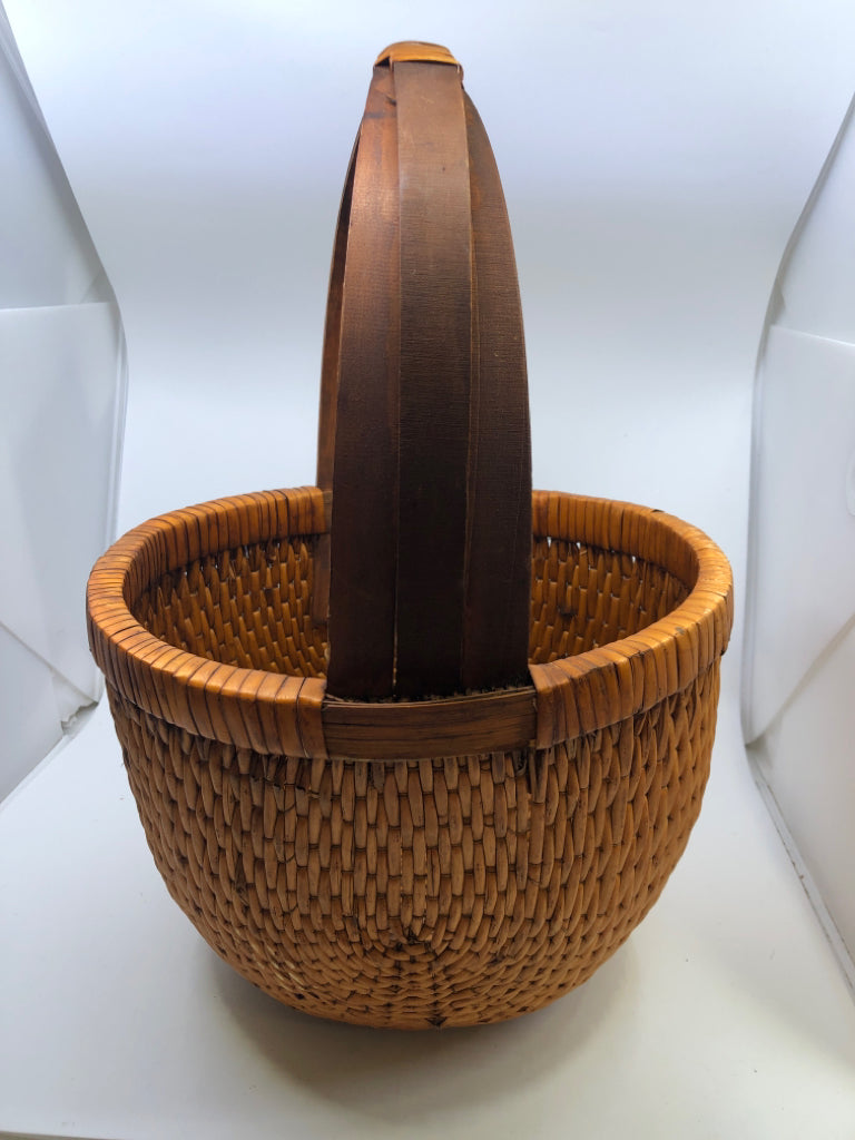 SMALL ROUND ORANGE TIGHT WEAVE BASKET W/ 3 CROSSED HANDLE.