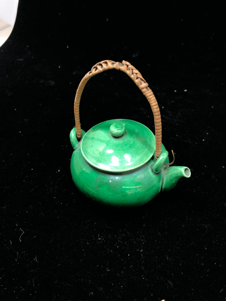 SMALL GREEN GLAZED TEA POT W/WICKER HANDLE.