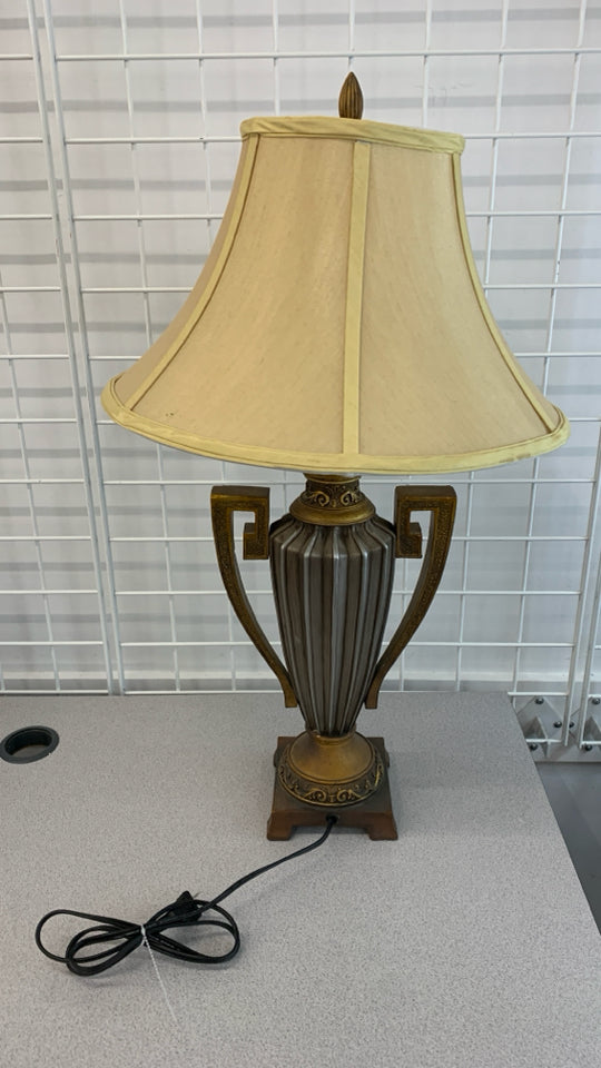 GOLDEN URN SHAPED LAMP W/TAN SHADE.
