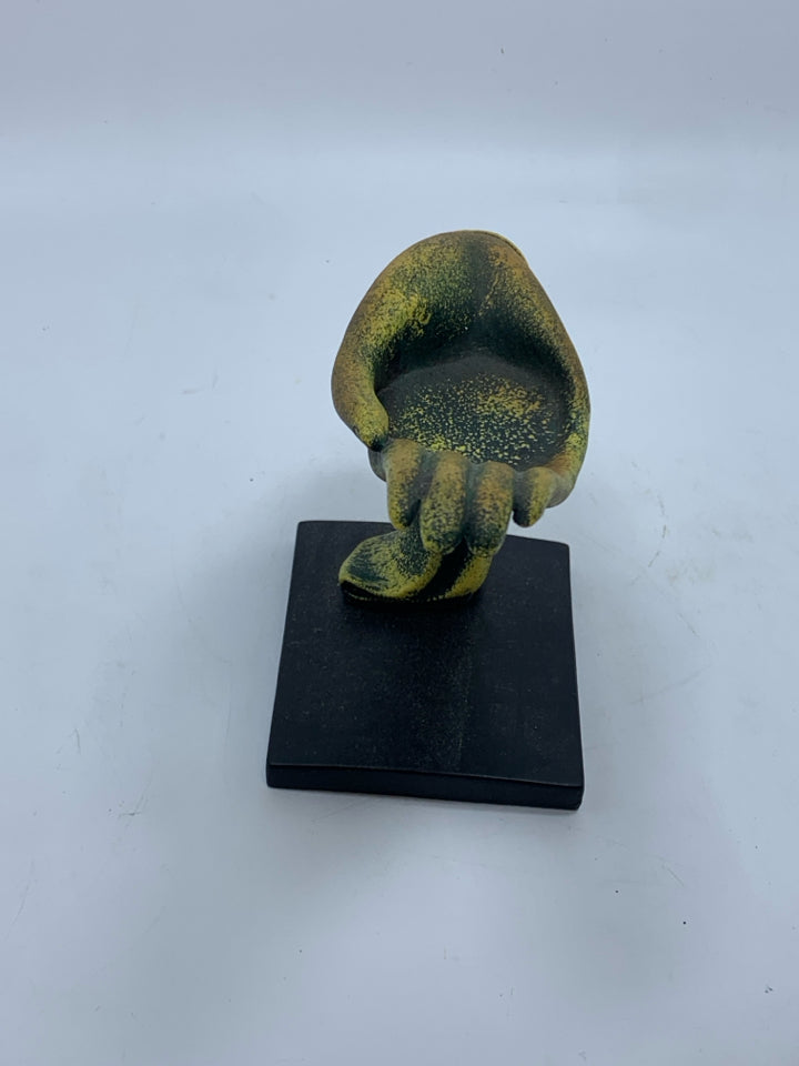 DISTRESSED GREEN AND GOLD HAND SCULPTURE ON BLACK BASE.