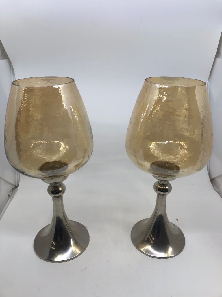 2 CANDLE HOLDERS W/ SILVER METAL BASE W/ AMBER+METALLIC GLASS SHADE.