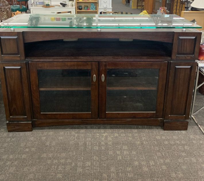 HEAVY DARK WOOD AND GLASS ENTERTAINMENT CENTER WITH SHELF AND CABINET STORAGE.