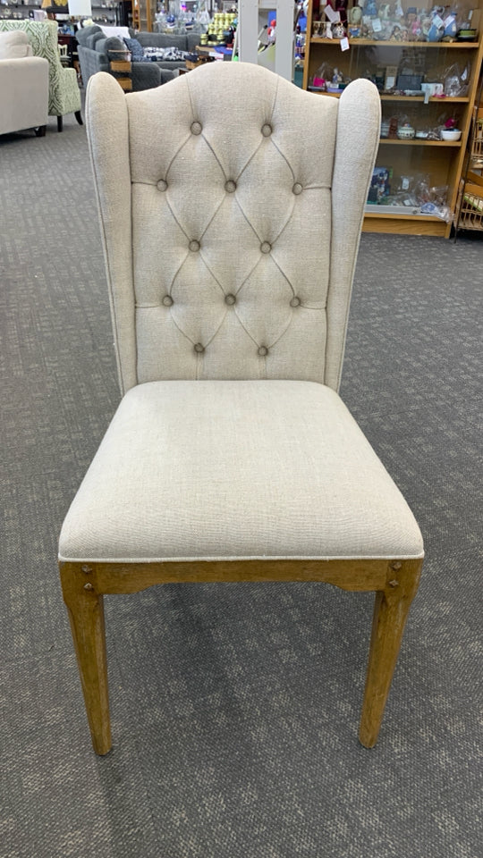 WHITE FABRIC CHAIR W/BROWN WOOD LEGS.