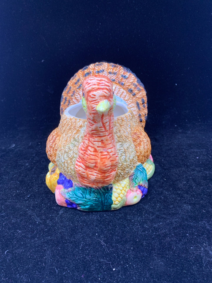 COLORFUL TURKEY BOWL SITTING ON FOOD.