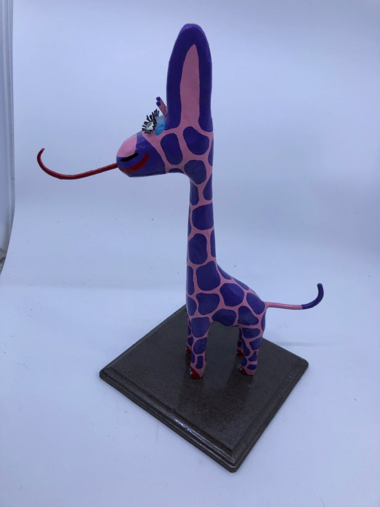 PINK AND PURPLE GIRAFFE ON WOOD STAND.