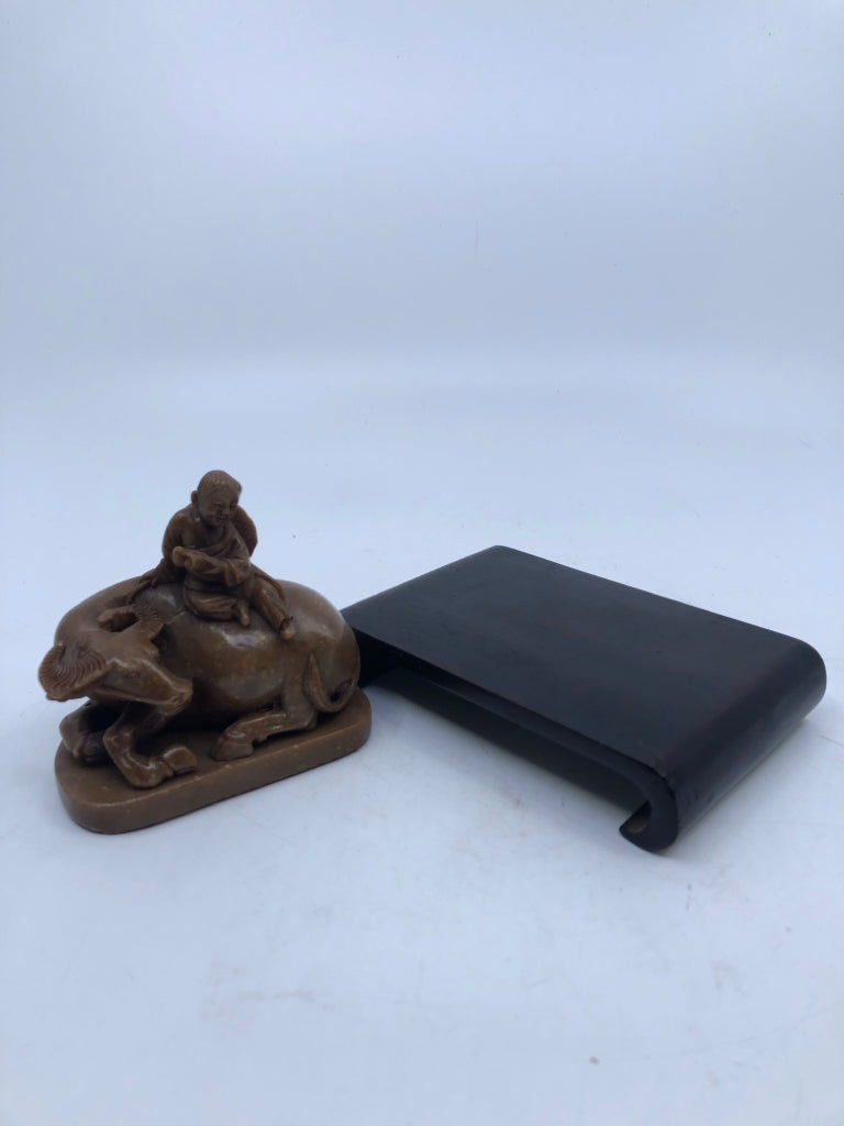 BROWN BULL & MAN FIGURINE ON WOOD SLAB.