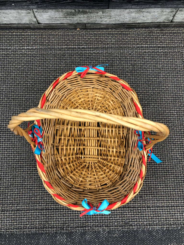 BLONDE WICKER BASKET W/BLUE AND RED BOWS.