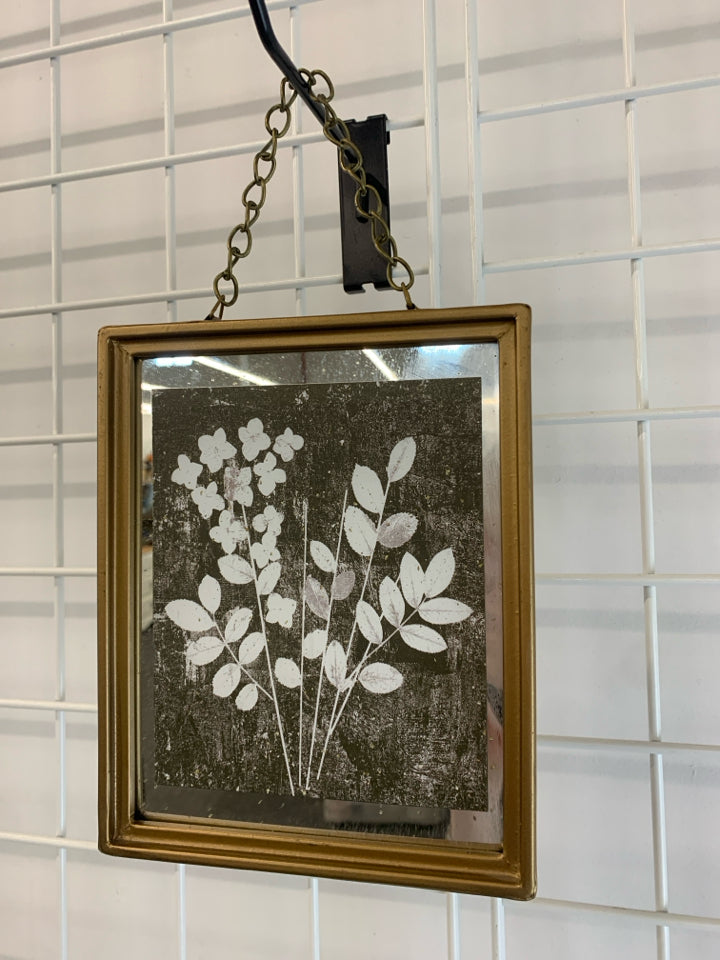 WHITE FLORAL PRINT IN HANGING BRASS FRAME.
