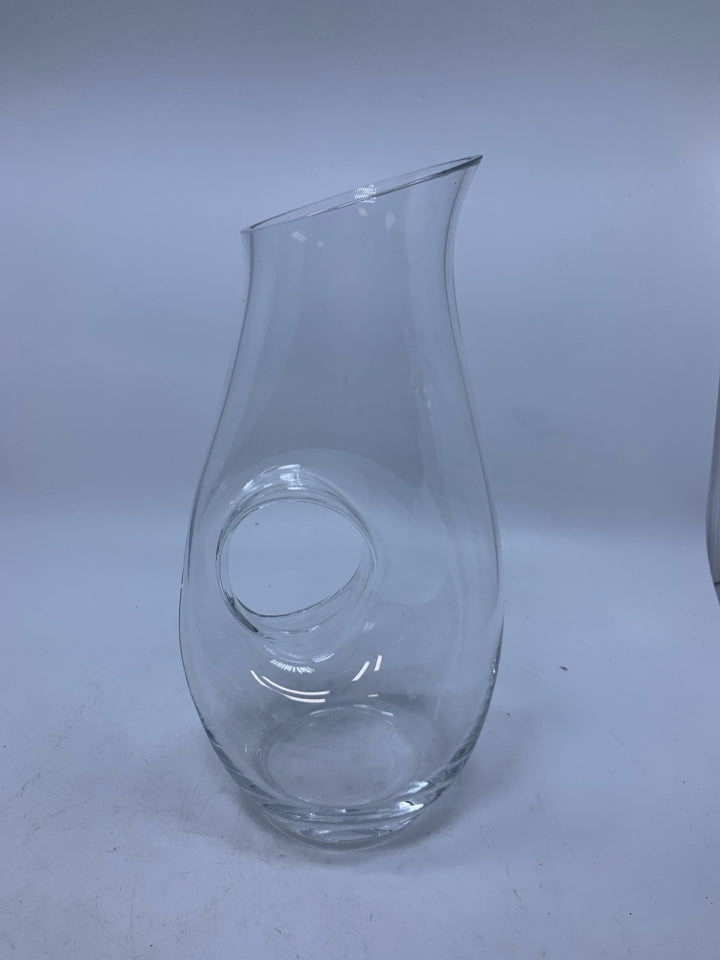 CLEAR GLASS PITCHER W/ CIRCLE HANDLE THROUGH CENTER.