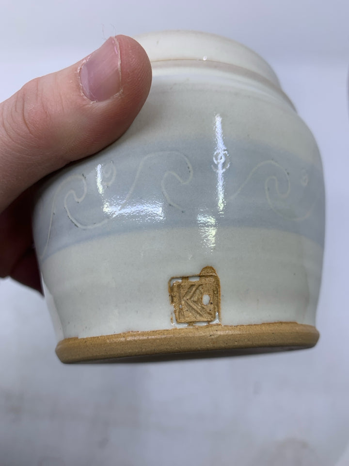 CREAM SHORT POTTERY CANISTER W/ LIGHT BLUE BAND WHITE WAVE OUTLINES.