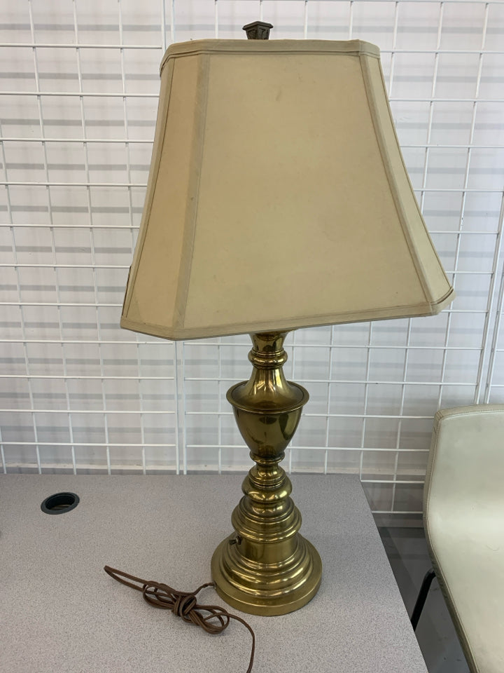 HEAVY GOLD BASE LAMP W/TAN SHADE.