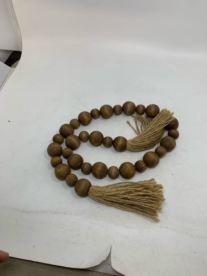 WOOD BEADED GARLAND W/ TWINE TASSELS.