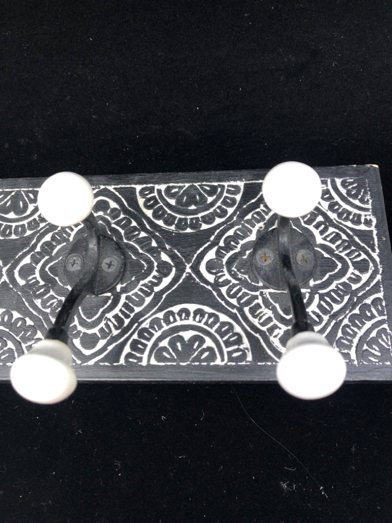 BLACK 3 HOOK  WALL ART W/ CARVED WHITE DETAILS.