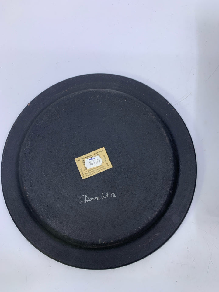 BLACK DECORATIVE PLATE W/ WHITE HOUSE SHEEP IN FRONT YARD.